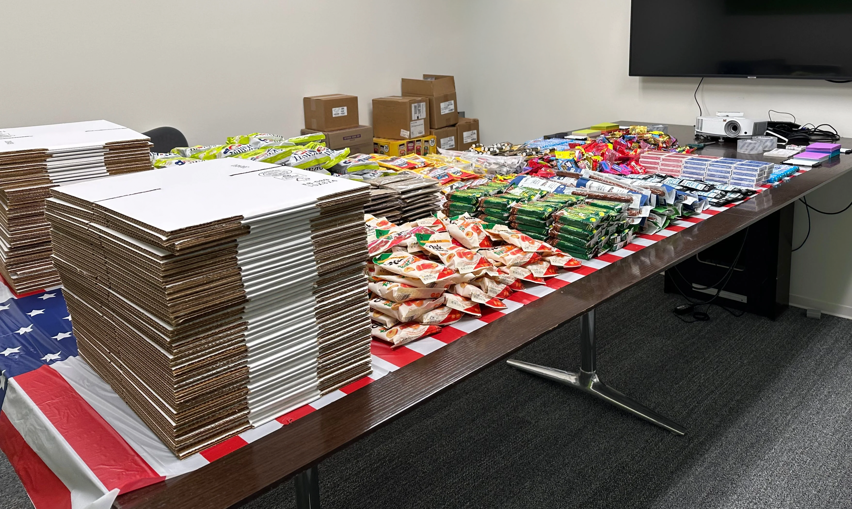 Care package supplies laid out on a table with American flag